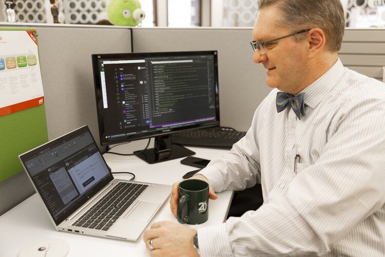 Male burwood employee working in cubicle on computer